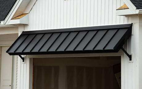 A Black Colorbond Awning on a Home Over Hanging a Large Open Door way — All Aussie Sunrooms in Port Stephens, NSW