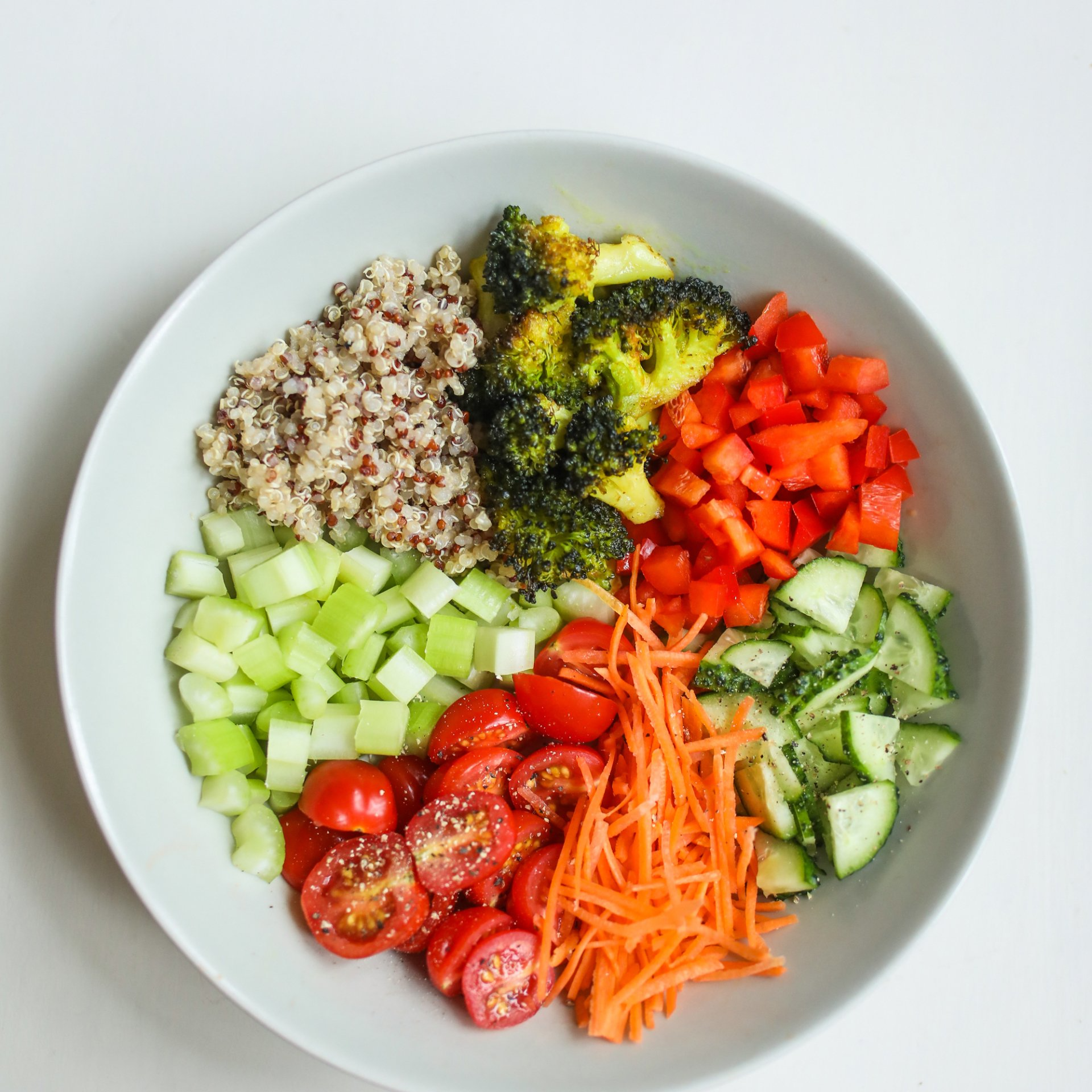 A bowl filled with vegetables and rice on a table.