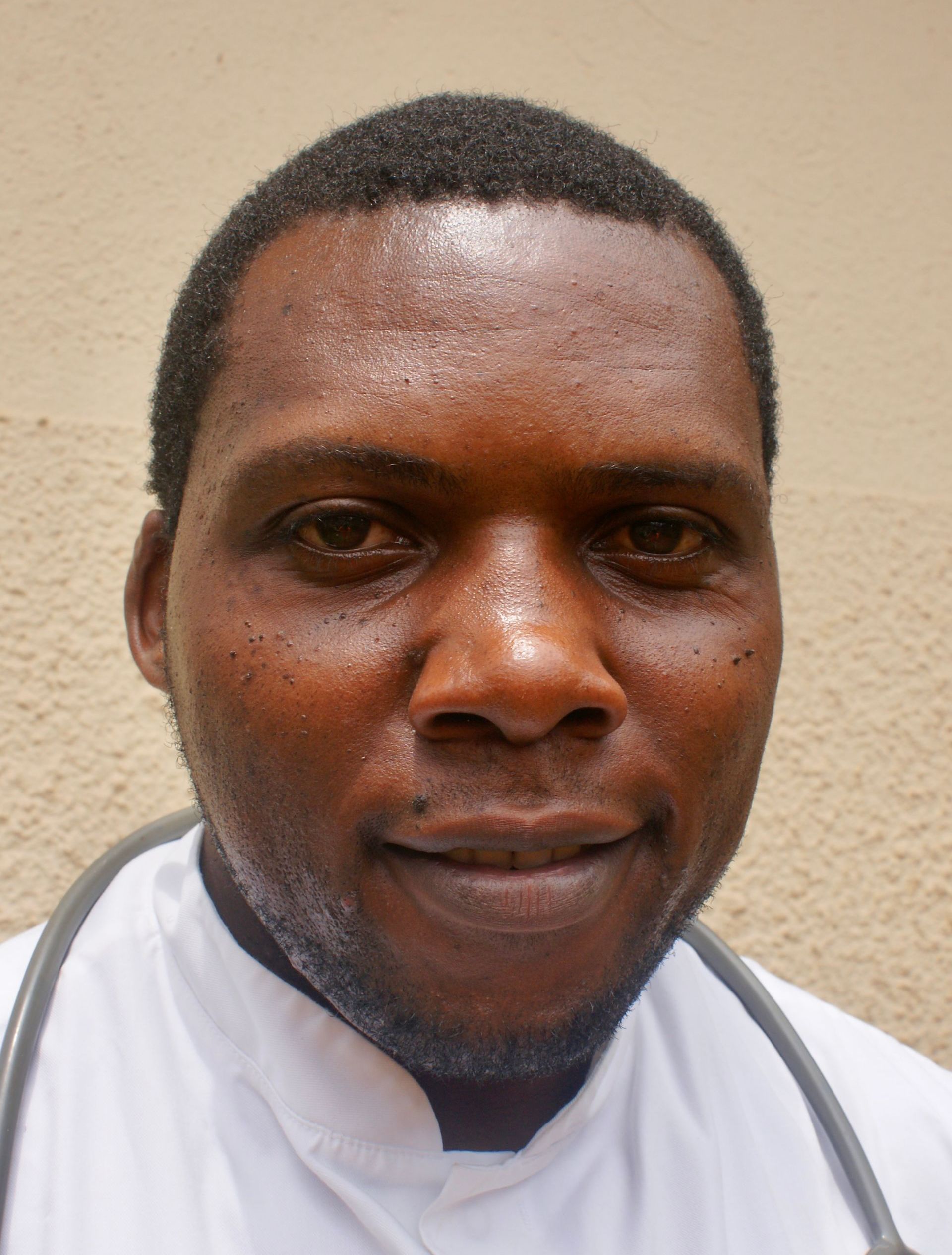 Man wearing a white coat and stethoscope, looking directly at the camera.