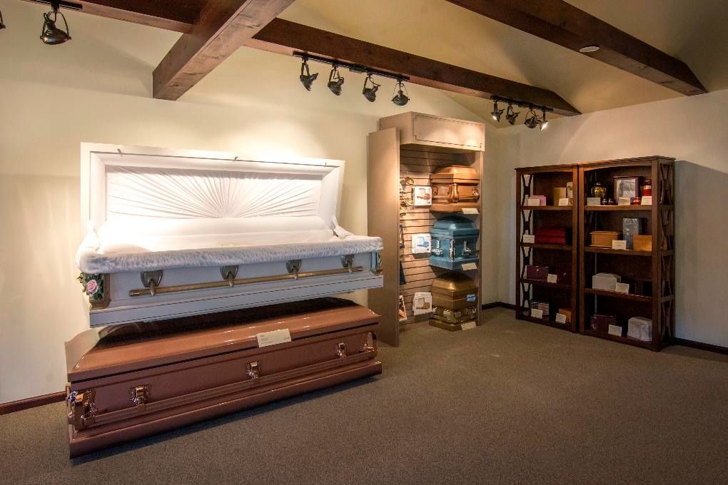 Spacious bedroom with two caskets, wooden beams, shelves, and track lighting
