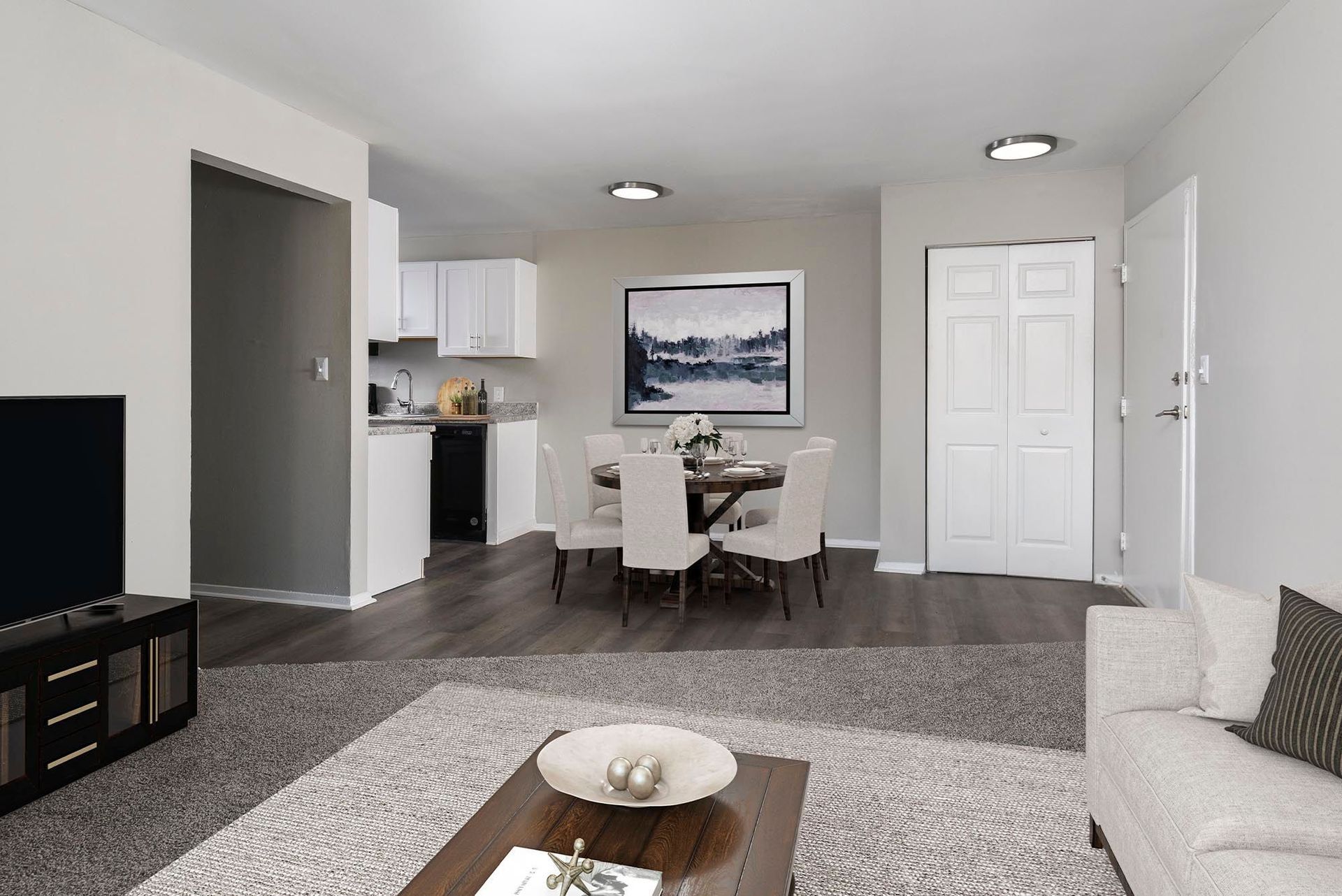 Open-concept living area with dining table, kitchen, and sofa at Chesapeake Pointe, offers Apartments for Rent in Chesapeake, VA.