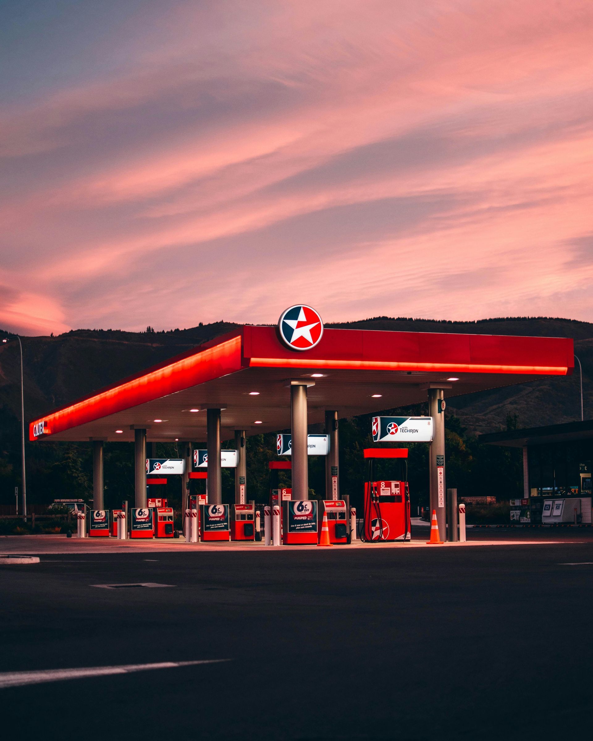 Station-service Red Texaco au coucher du soleil avec un ciel rose.