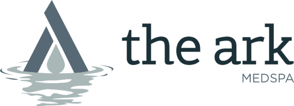 The logo for the ark medspa shows a boat in the water.