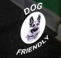 A circular sticker on a glass door features a German Shepherd and the text