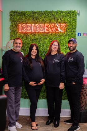 Owners of Micro Creamery and family against green wall with an