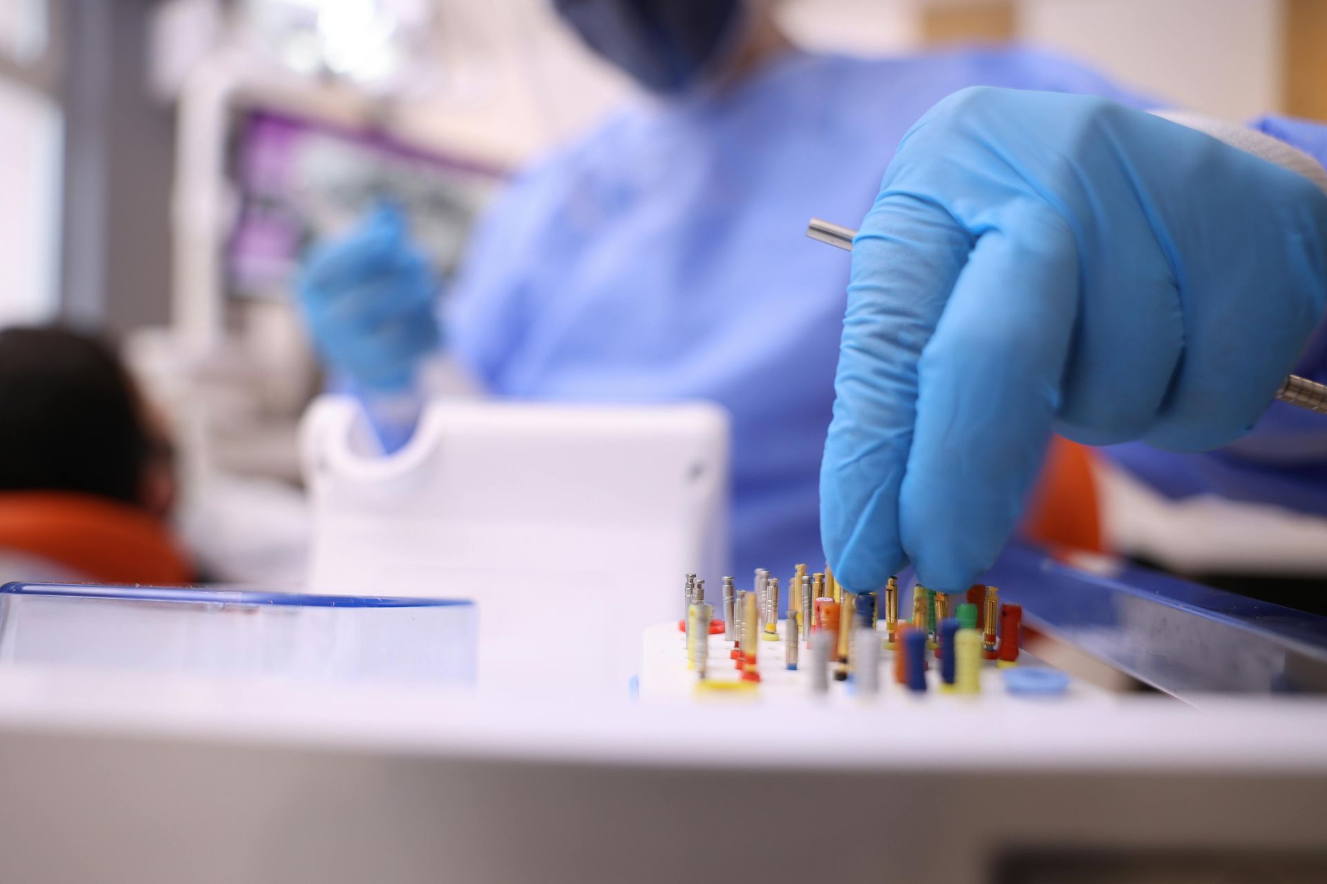 Mani guantate che maneggiano minuscoli campioni colorati su un tavolo da laboratorio in un laboratorio medico