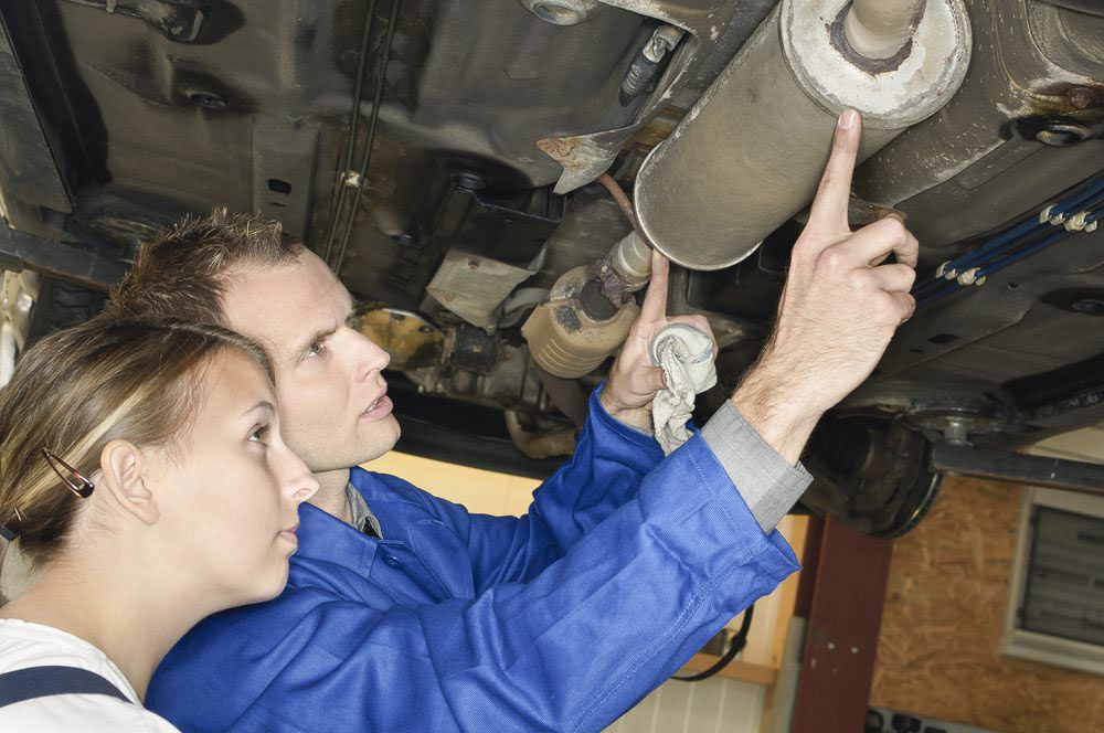 Mechanic Checking Cars Muffler— Exhaust Shop in Kempsey, NSW