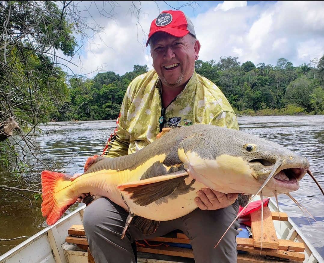 Guide holding large Amazon River catfish during big game fishing trip