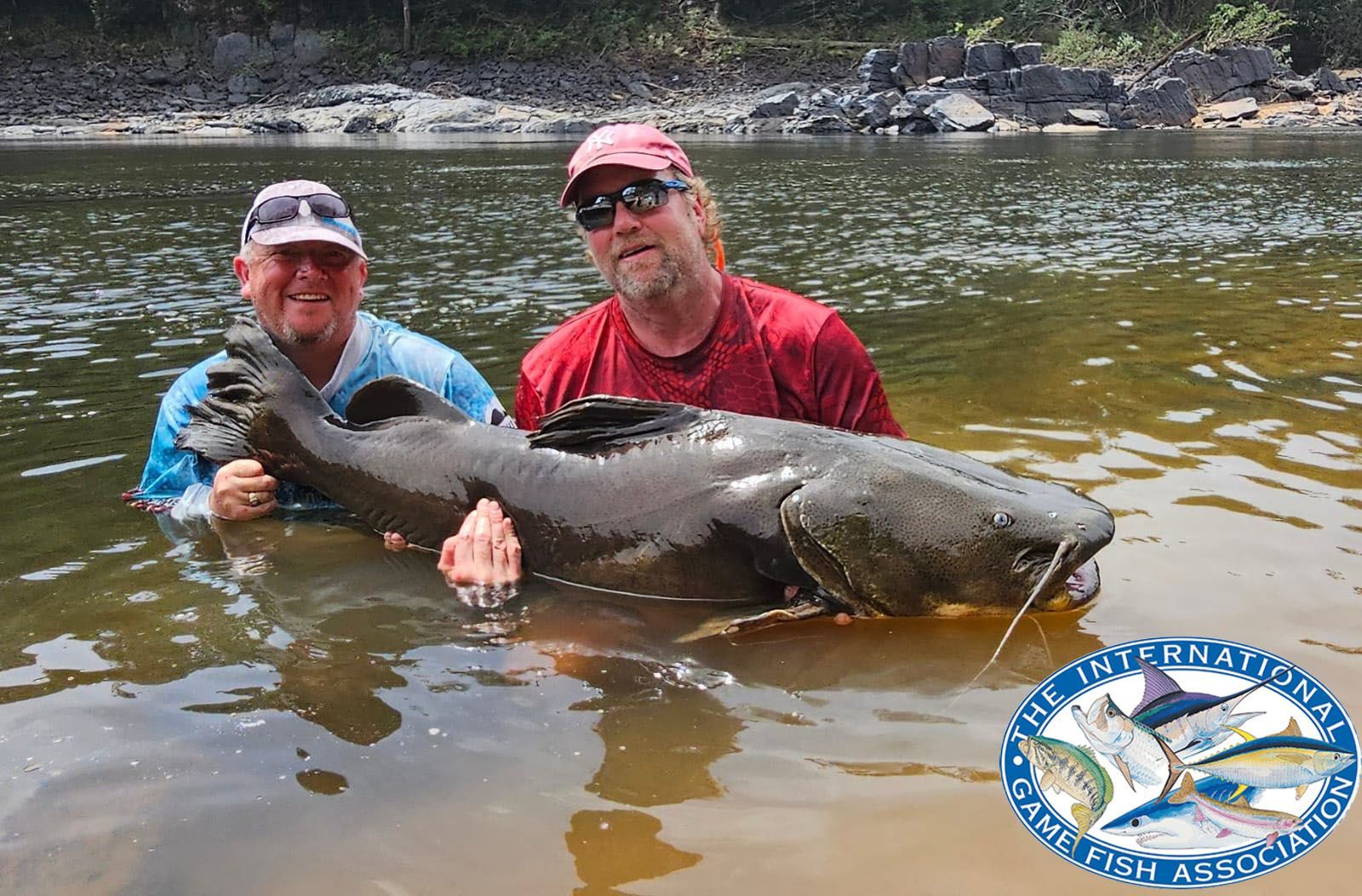 Anglers holding giant Amazon River catfish during Guyana fishing expedition