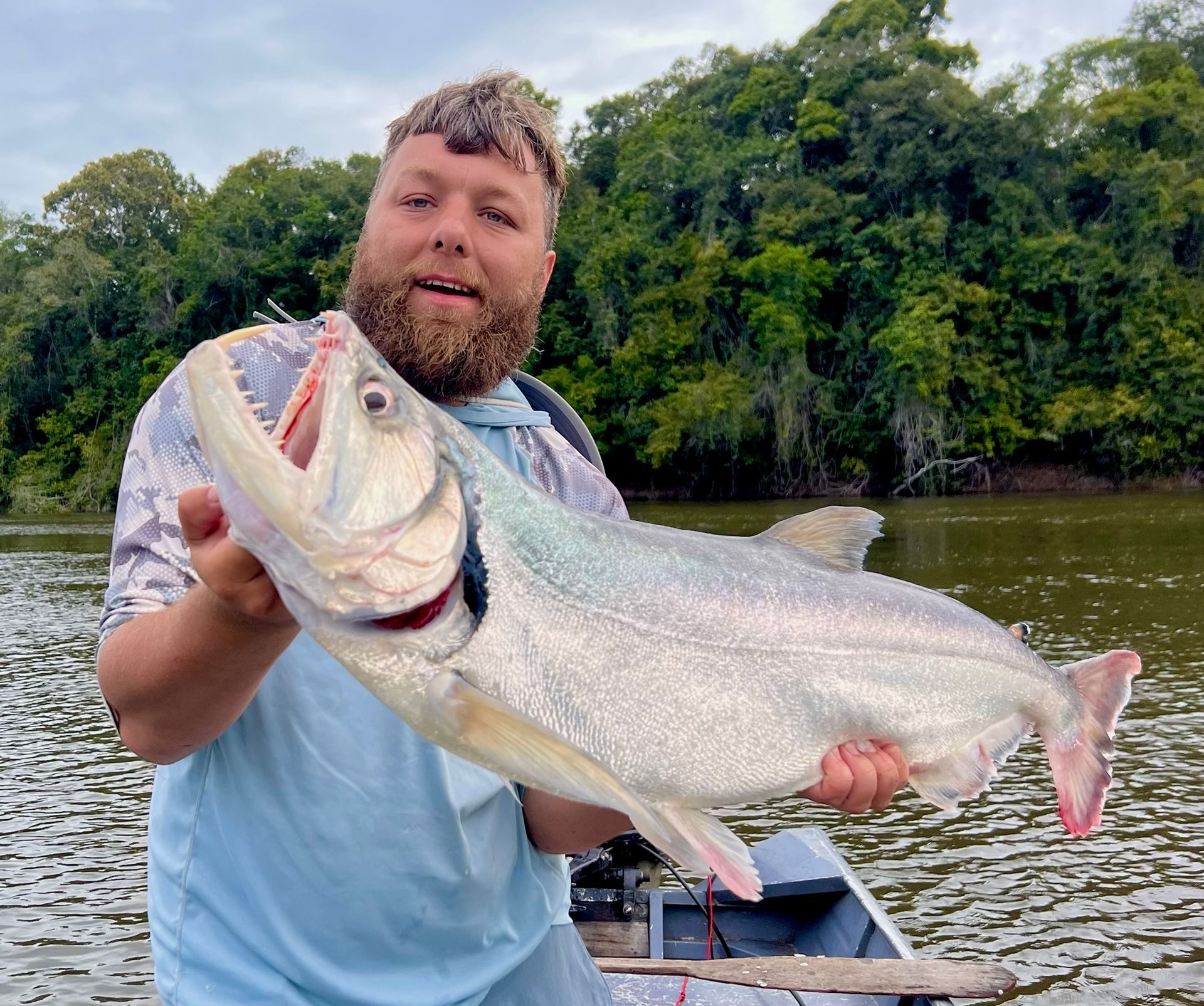 Amazon River jungle specialist guide holding trophy catfish
