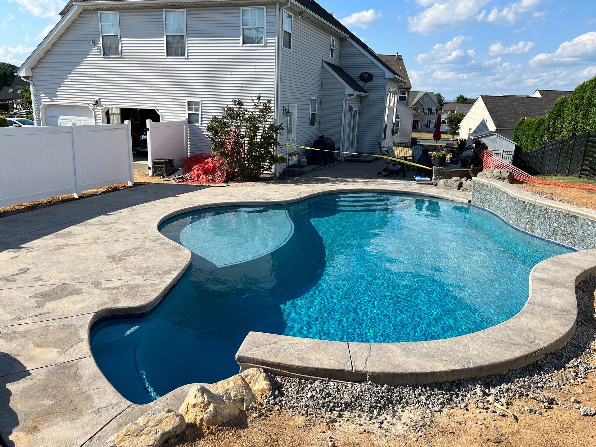 a large swimming pool is in the backyard of a house .
