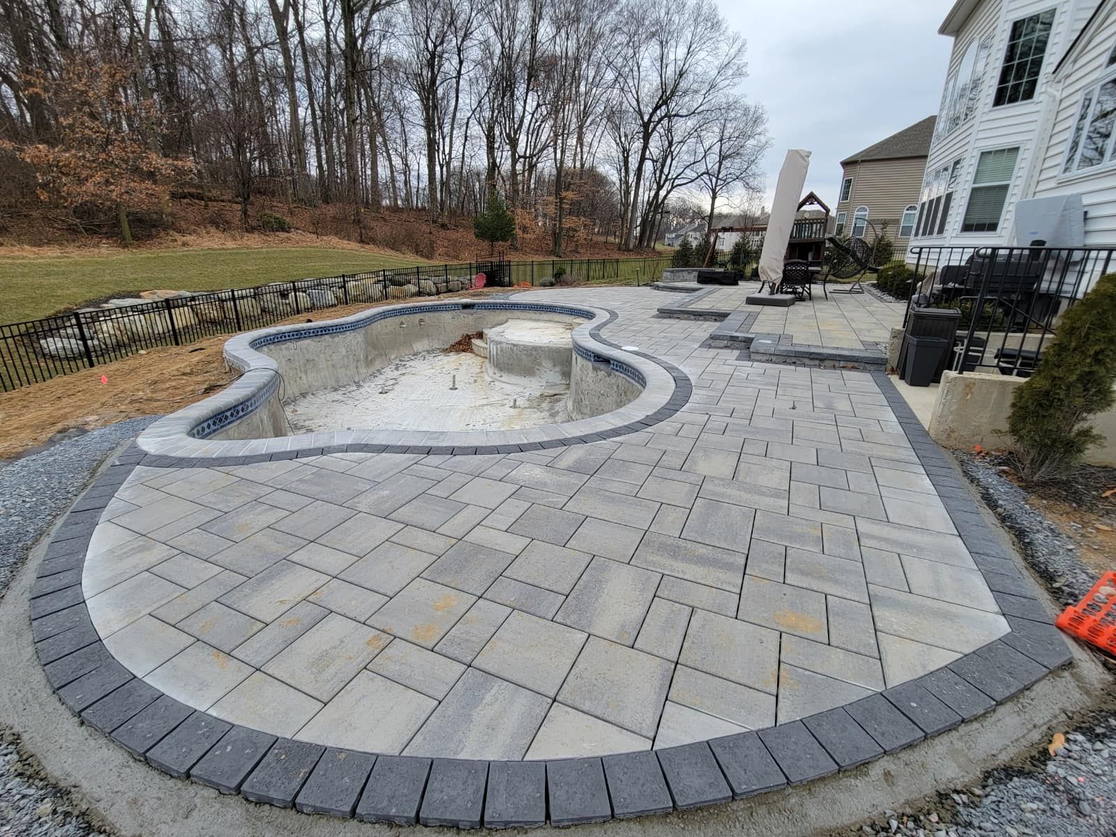 a large swimming pool is being built in the backyard of a house .