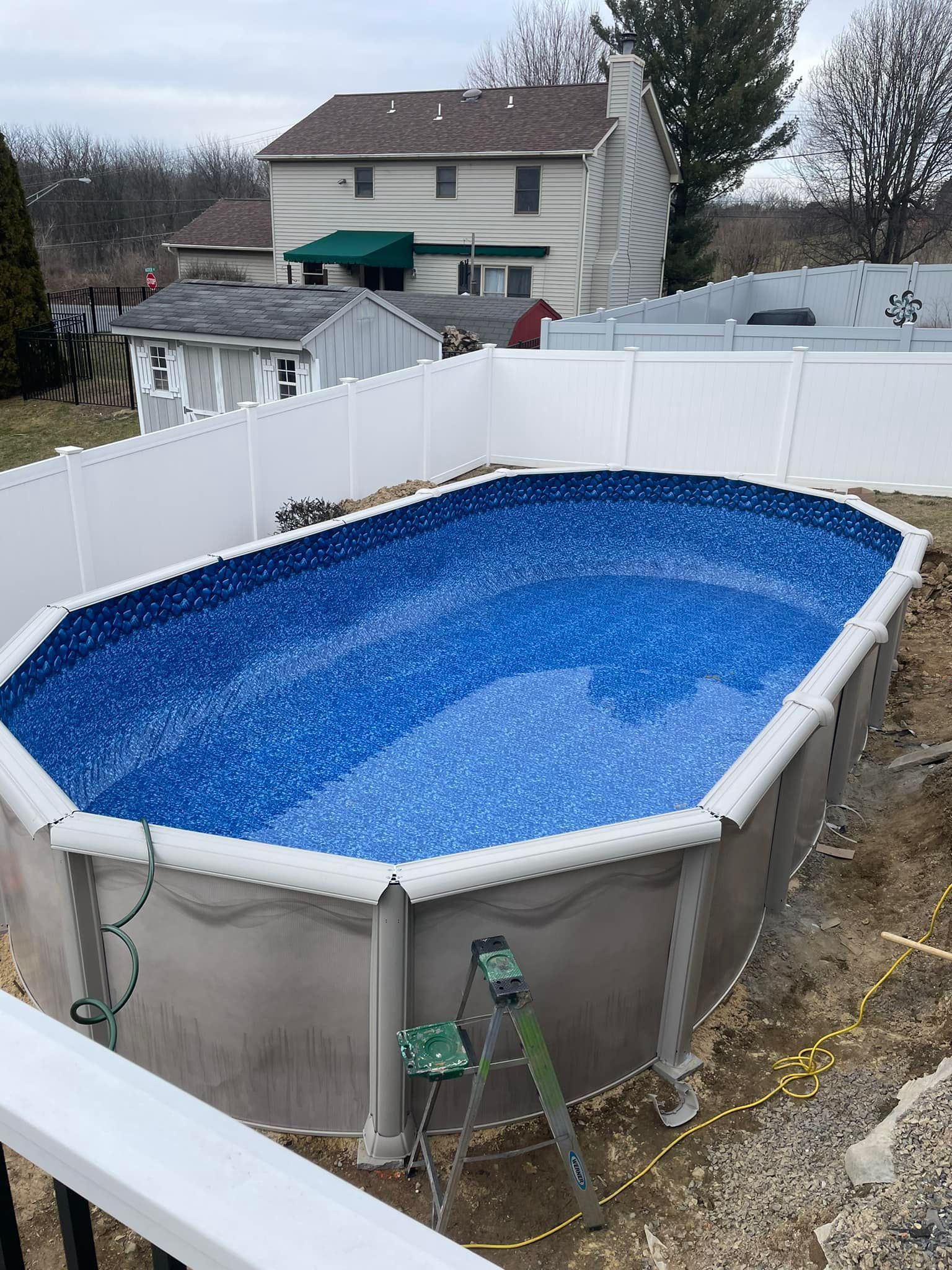 a large swimming pool is being built in the backyard of a house .