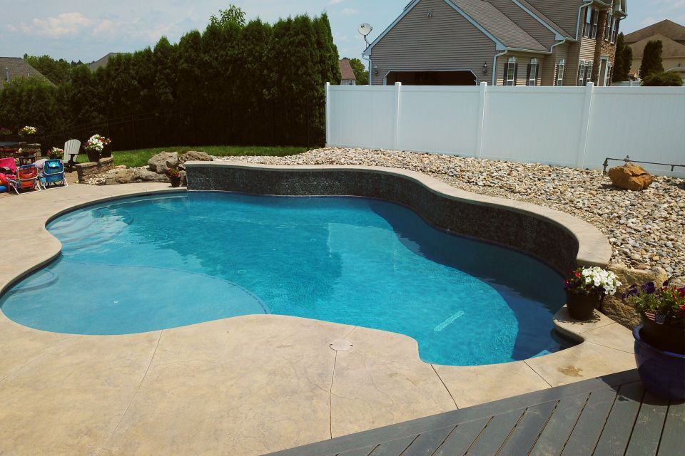 a large swimming pool with a white fence surrounding it