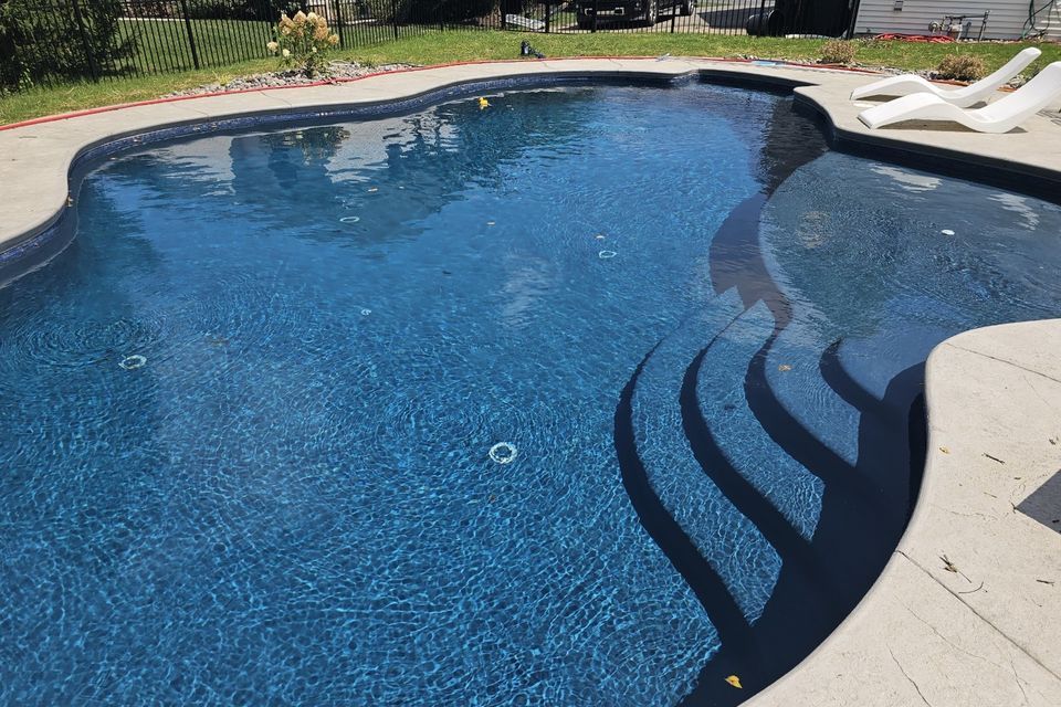 a large swimming pool with stairs leading to it