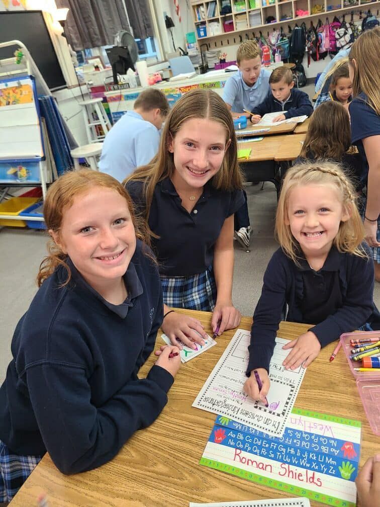 A group of young girls are sitting at a table in a classroom