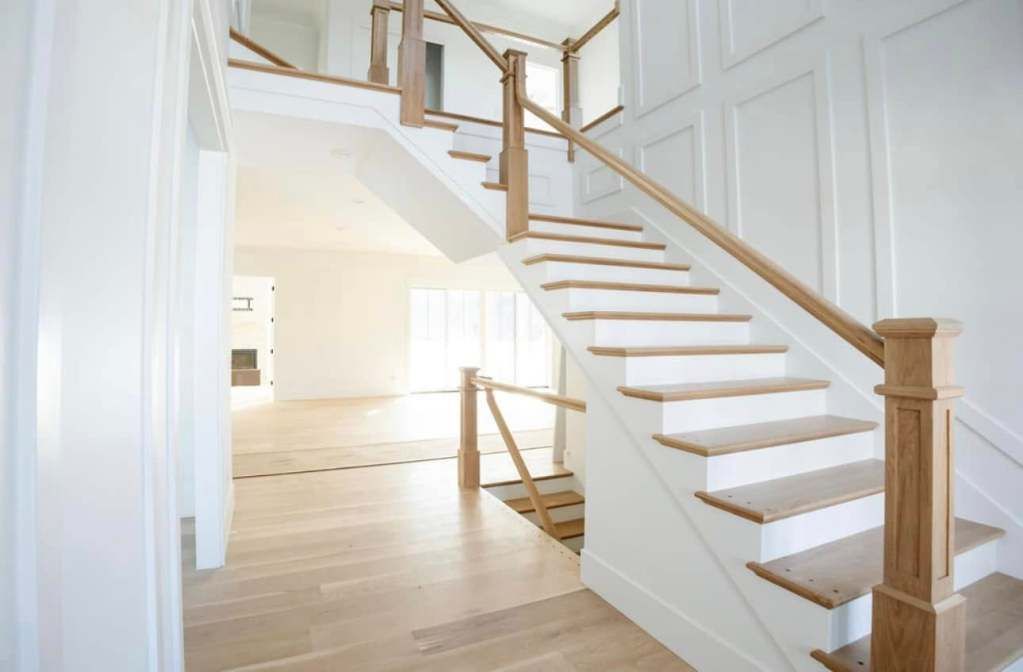 Wooden staircase with white risers, leading to a second floor. Light wood flooring and walls. Wooden staircase with white risers, leading to a second floor. Light wood flooring and walls.