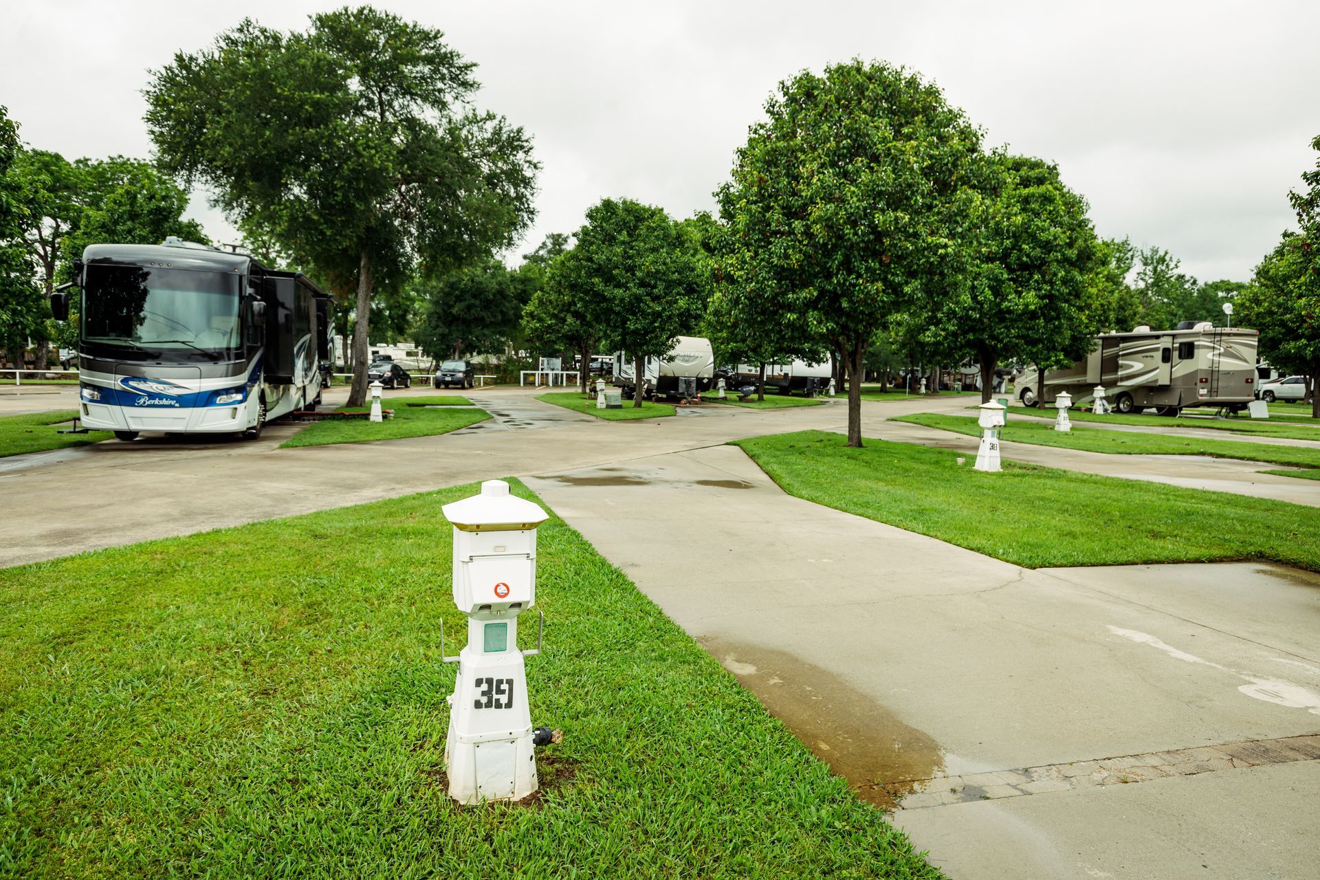 A rv is parked next to a fire hydrant in a campground.