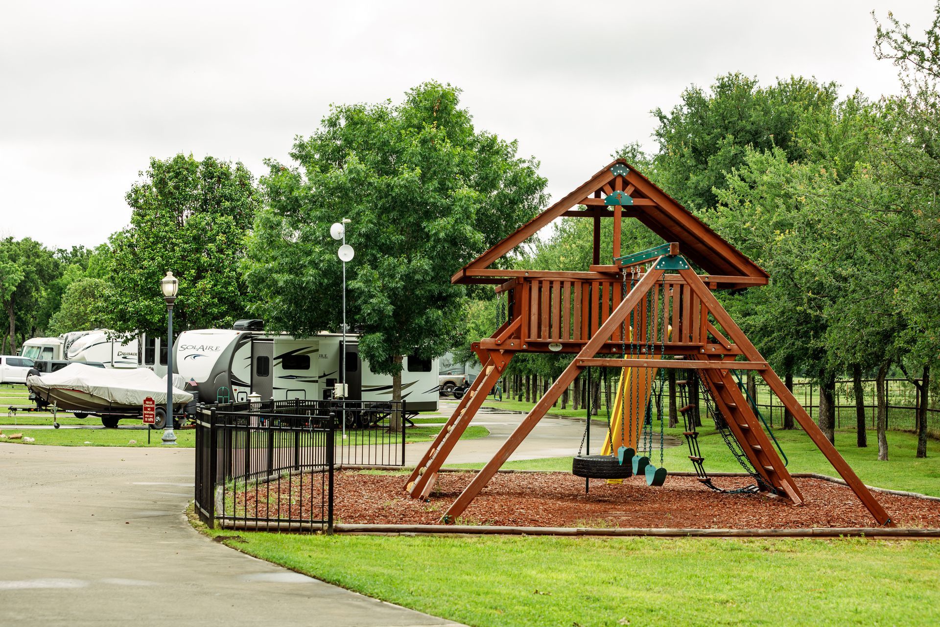 A playground with a swing set and a slide in a park.