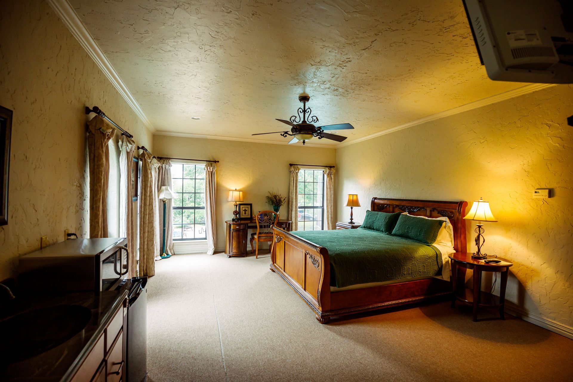 A large bedroom with a king size bed and a ceiling fan.