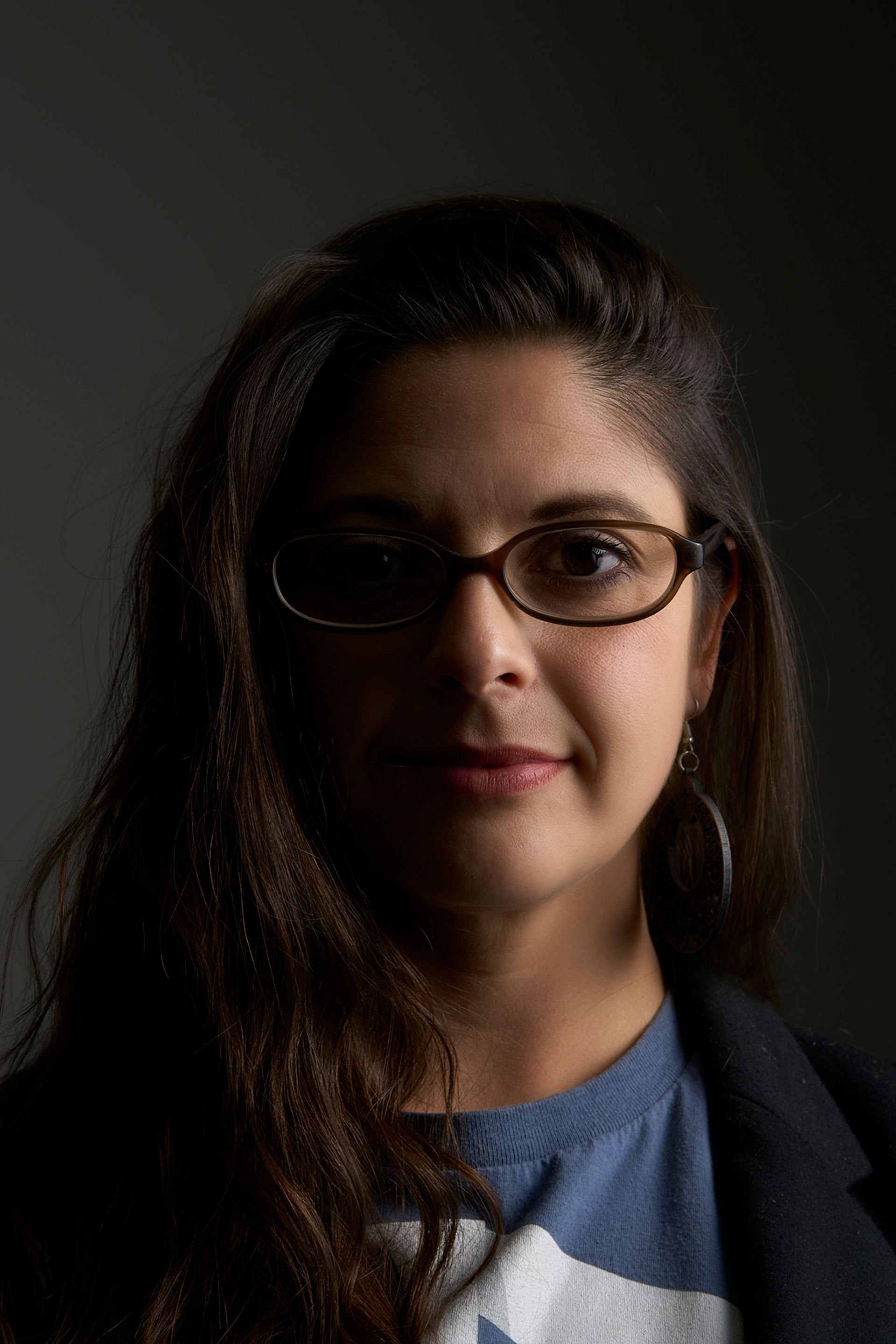 A woman wearing glasses and a blue shirt