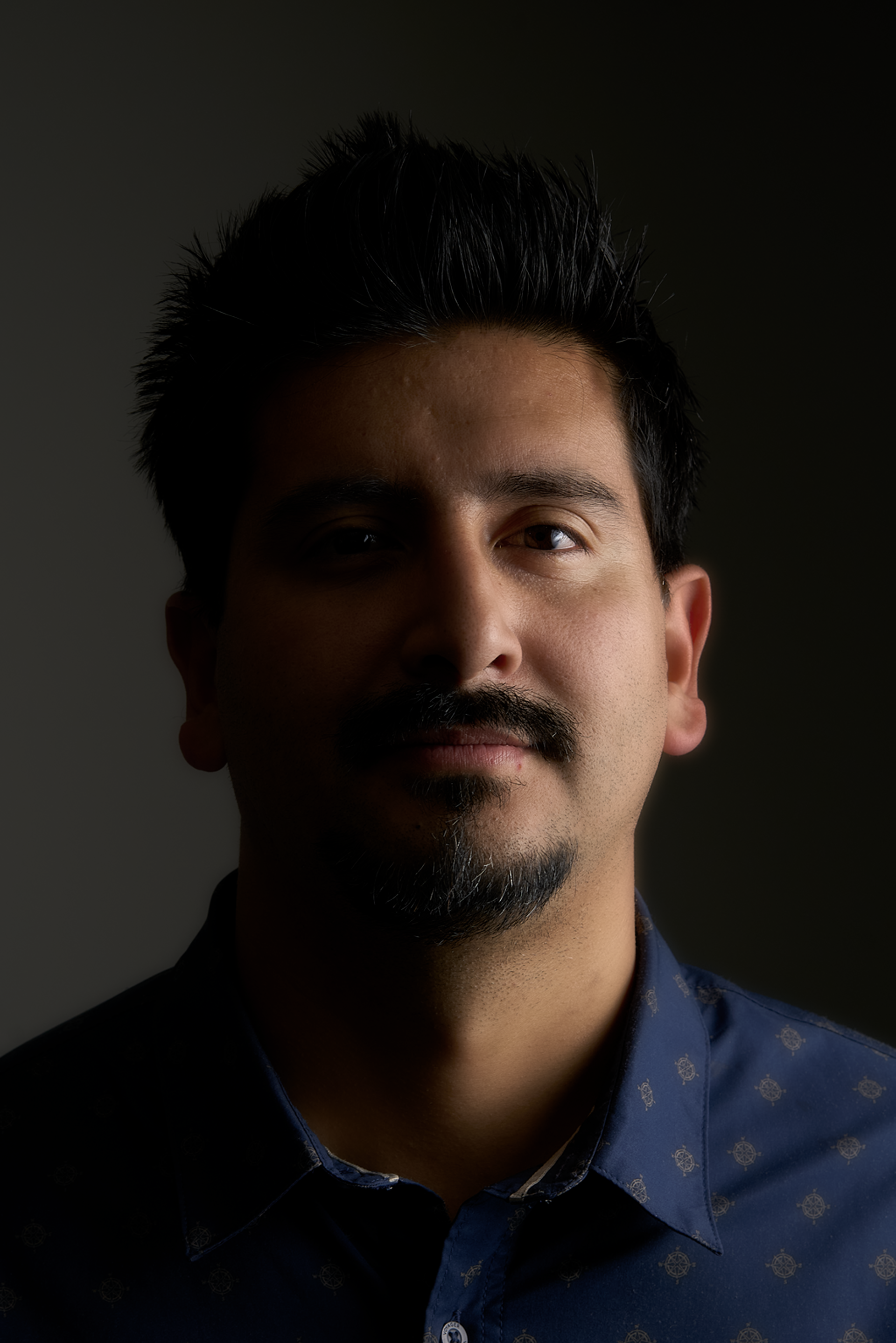 A man with a beard is wearing a blue shirt