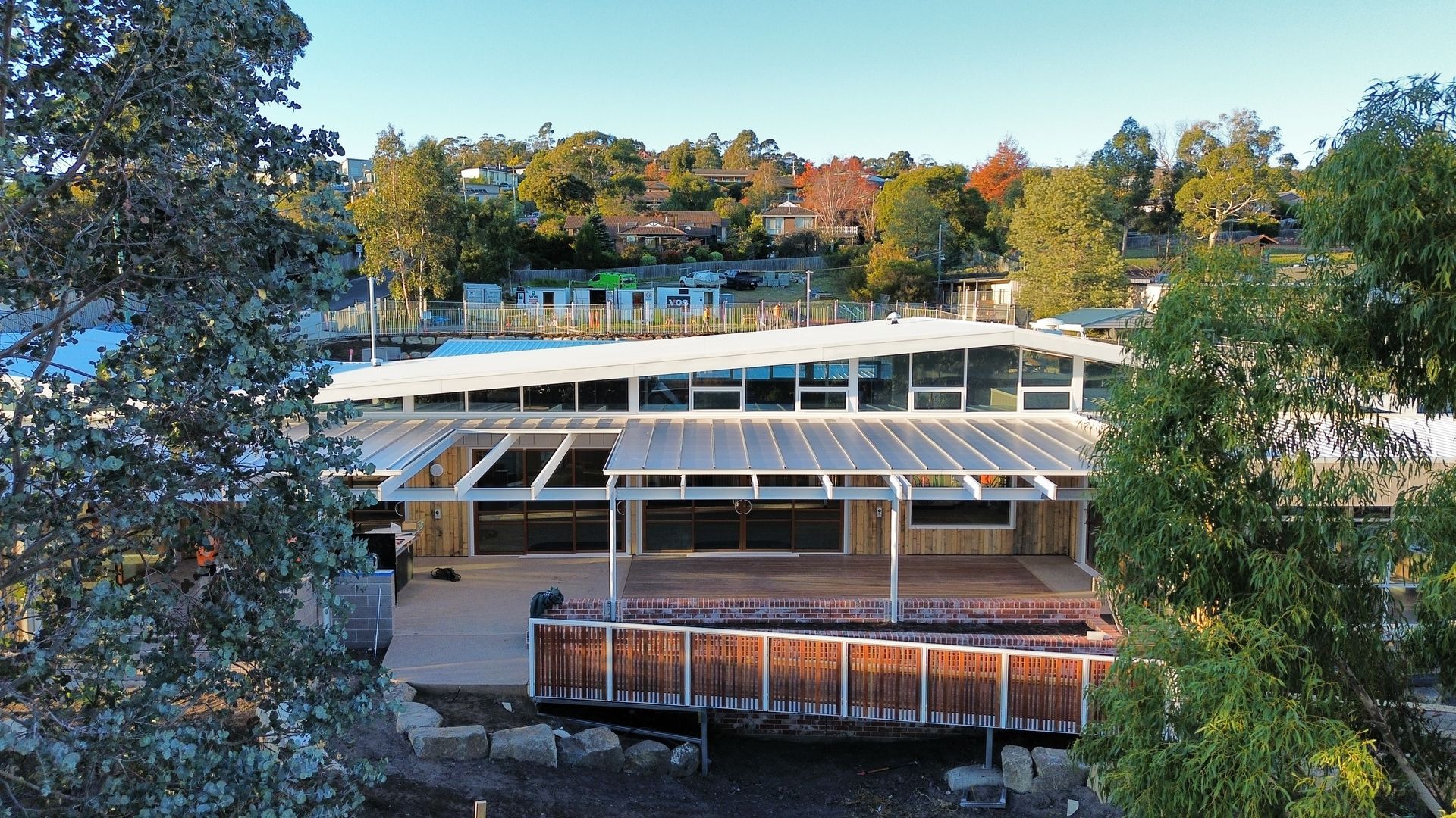 An aerial view of a house with a white roof surrounded by trees.