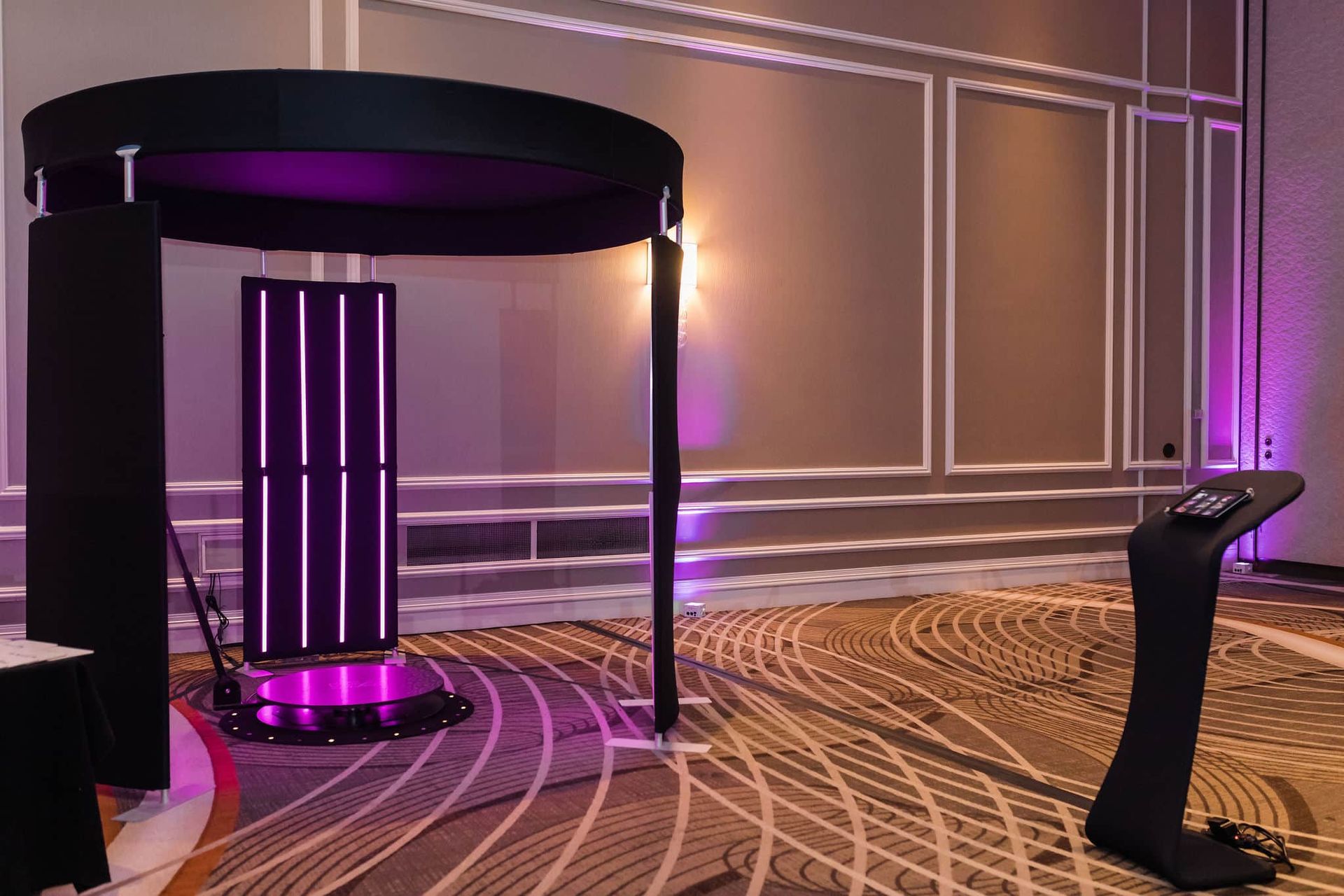 A photo booth is sitting in a room with purple lights.