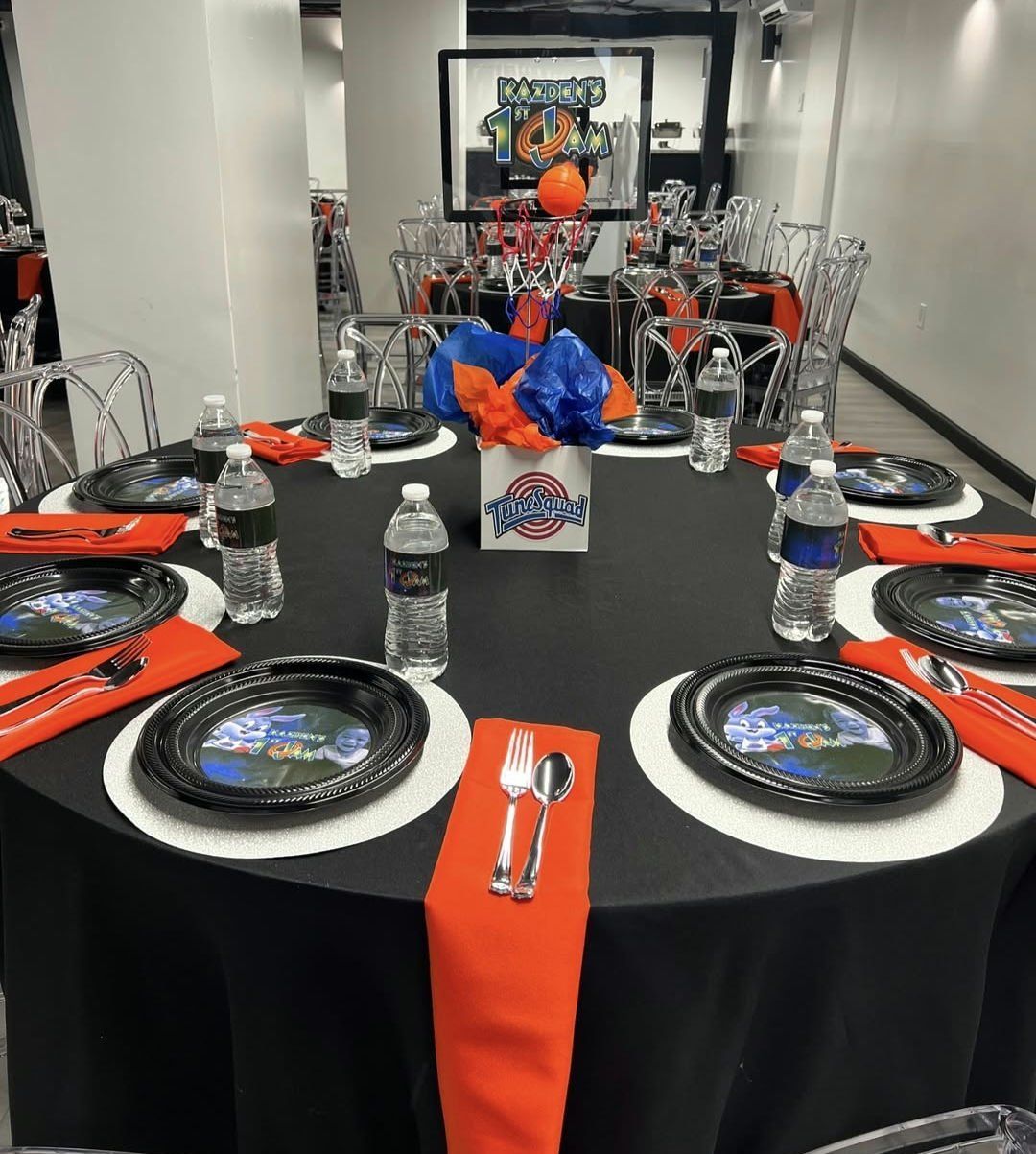 A table set for a party with plates utensils and water bottles