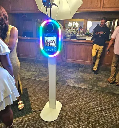 A group of people are standing around a photo booth.