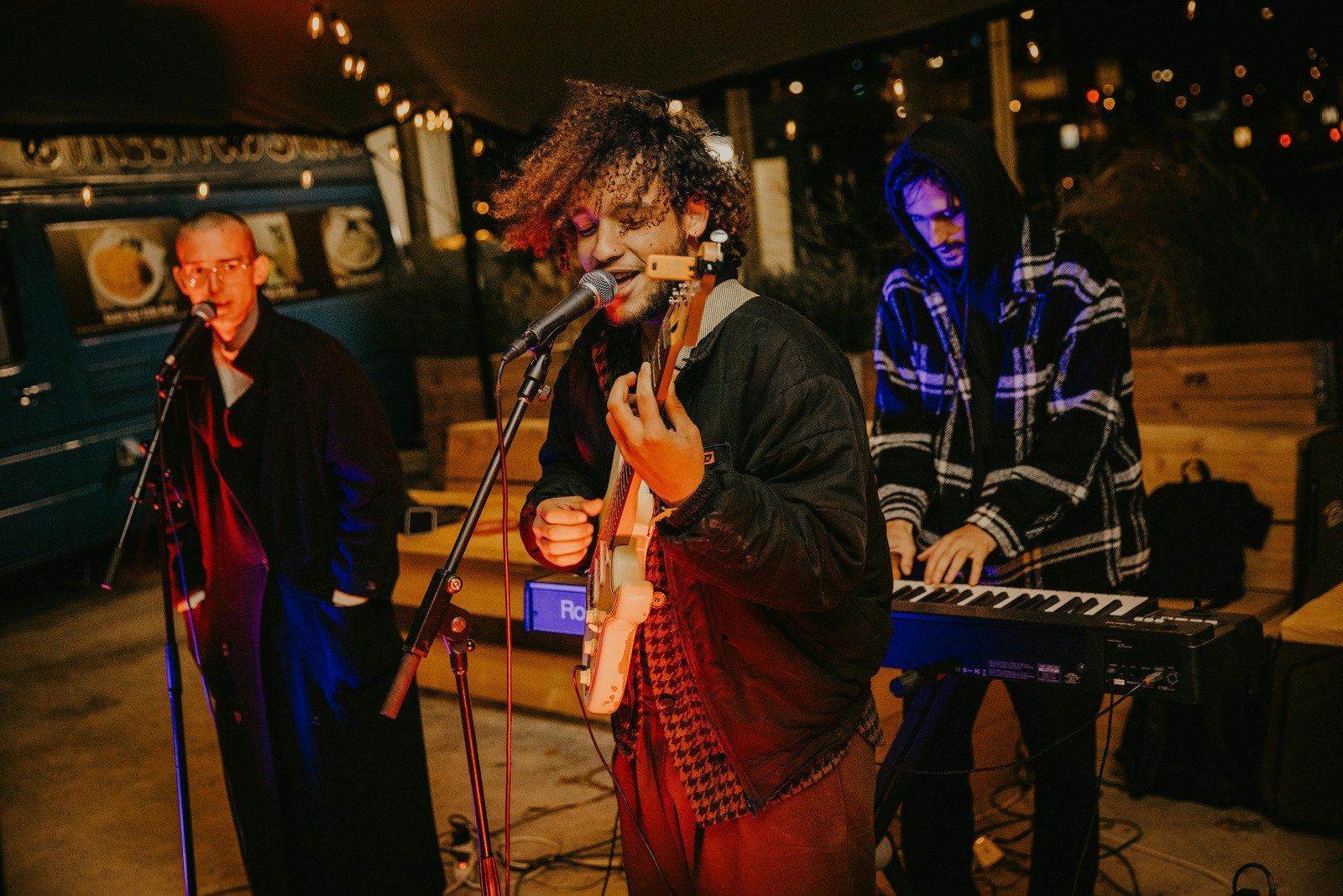 A group of people are playing instruments and singing into microphones on a stage.