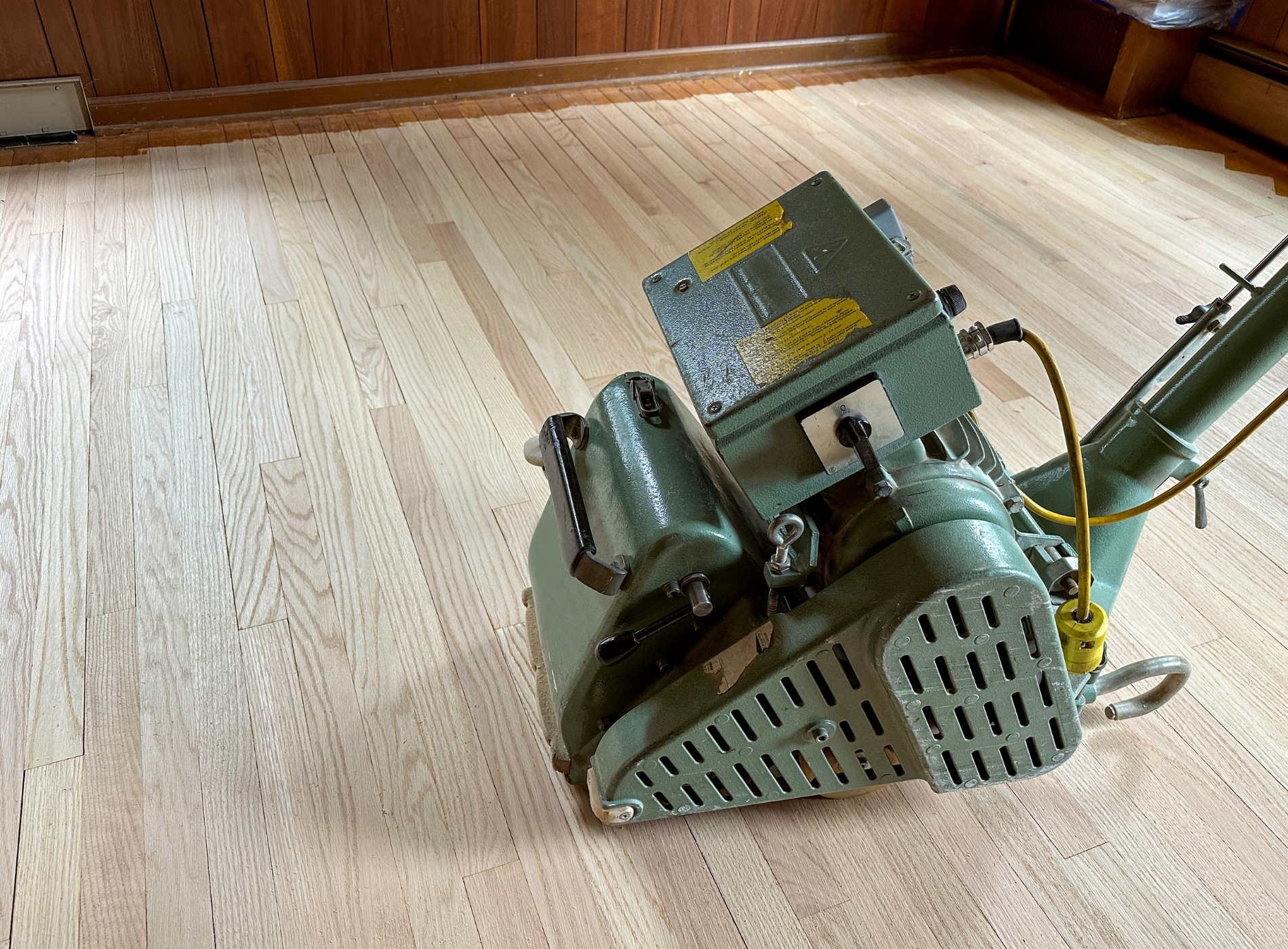 A machine is sitting on a wooden floor in a room.