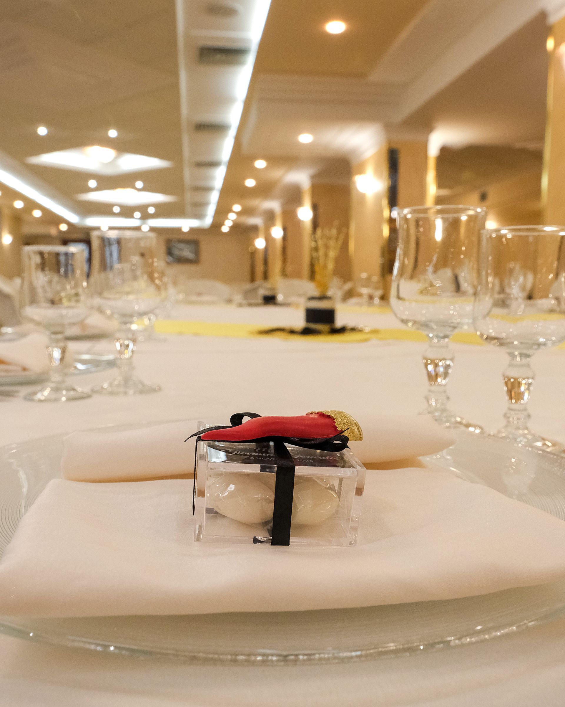 Tavolo da pranzo formale apparecchiato con apparecchiatura e centrotavola in una sala per banchetti.