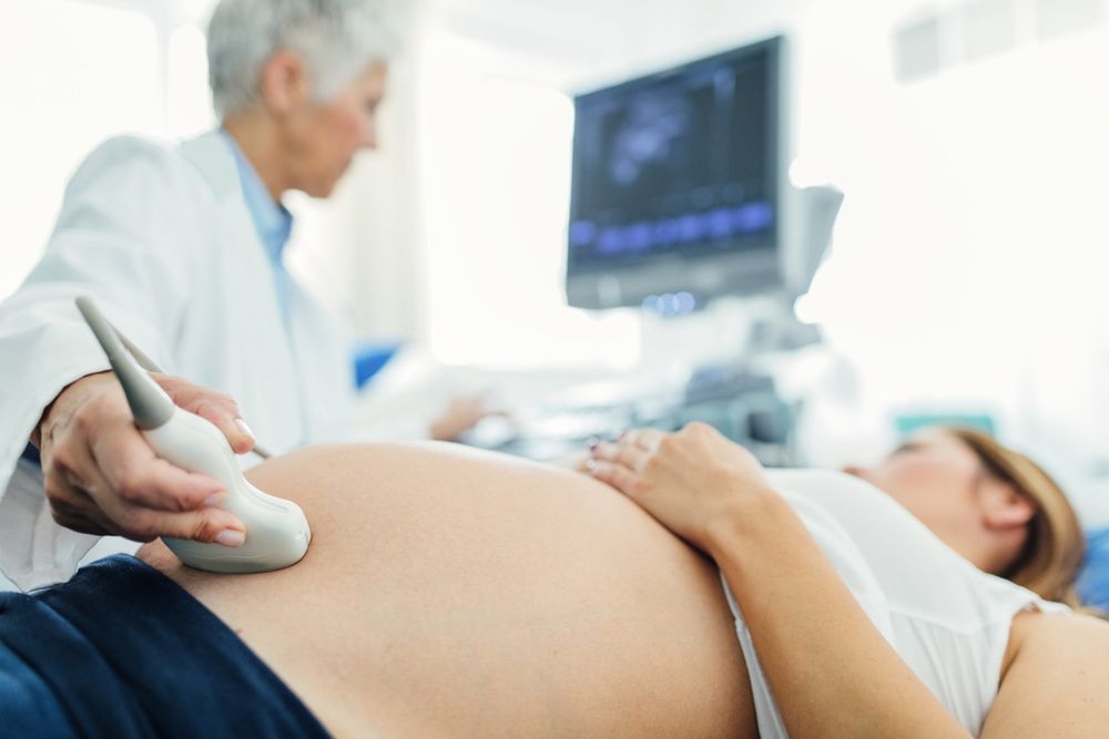 Ostetrica effettua un ecografia su una giovane donna