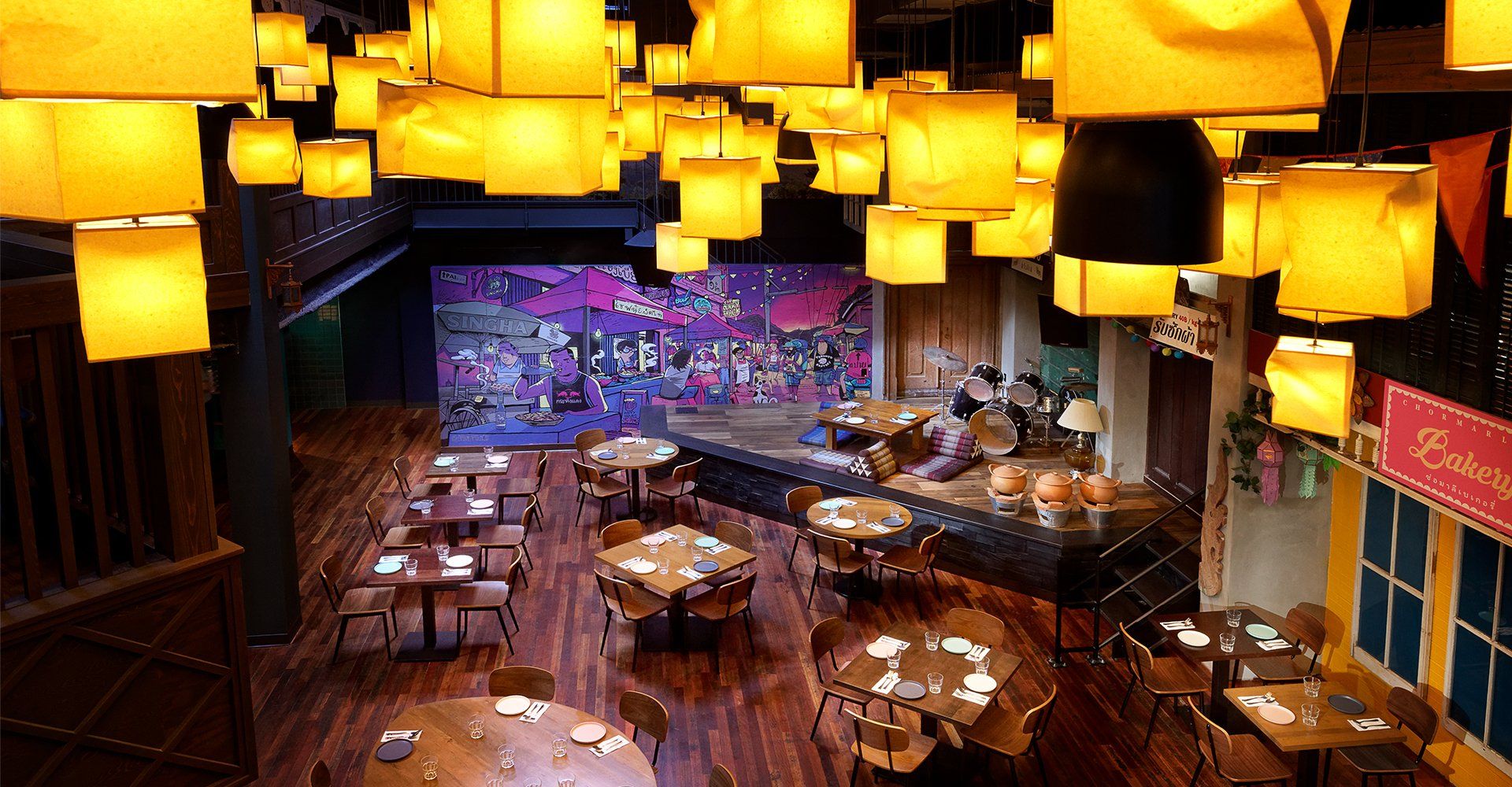 An aerial view of a restaurant with tables and chairs and a stage.