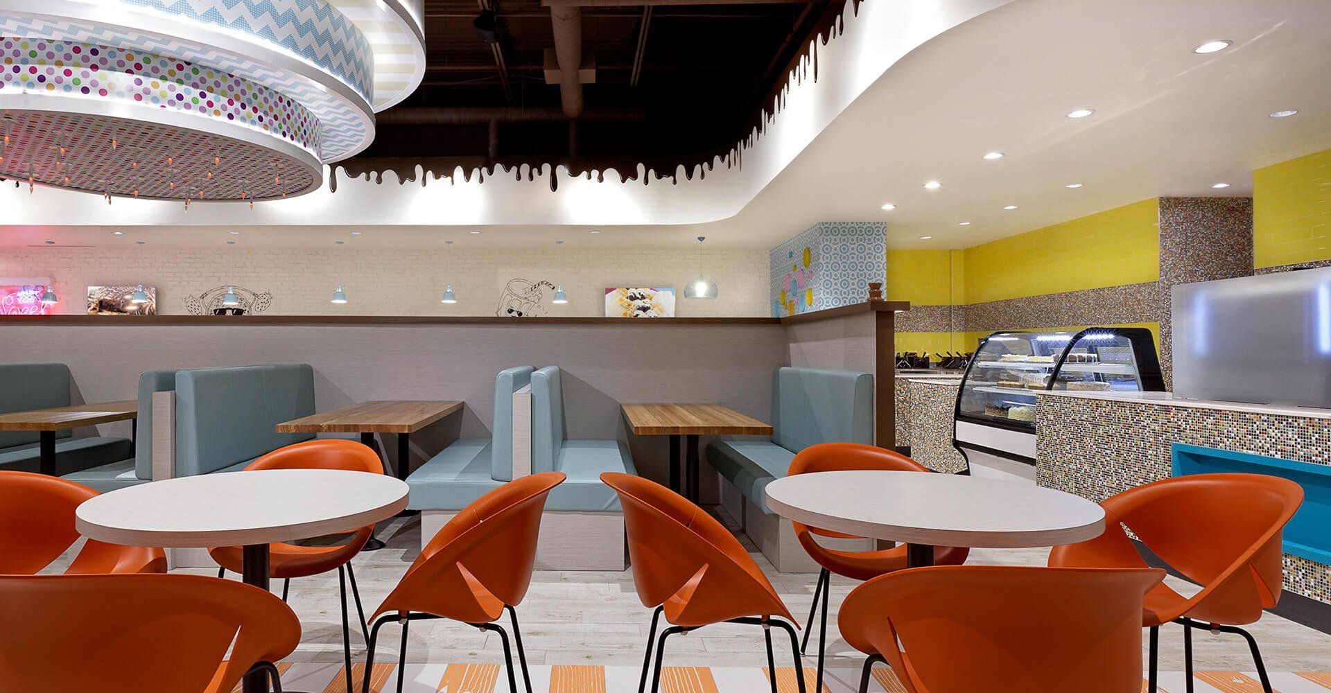 A restaurant with tables and chairs and a chandelier hanging from the ceiling.