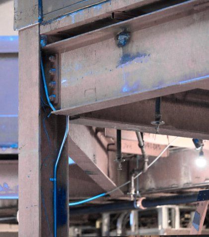 A close up of a metal structure with blue wires coming out of it