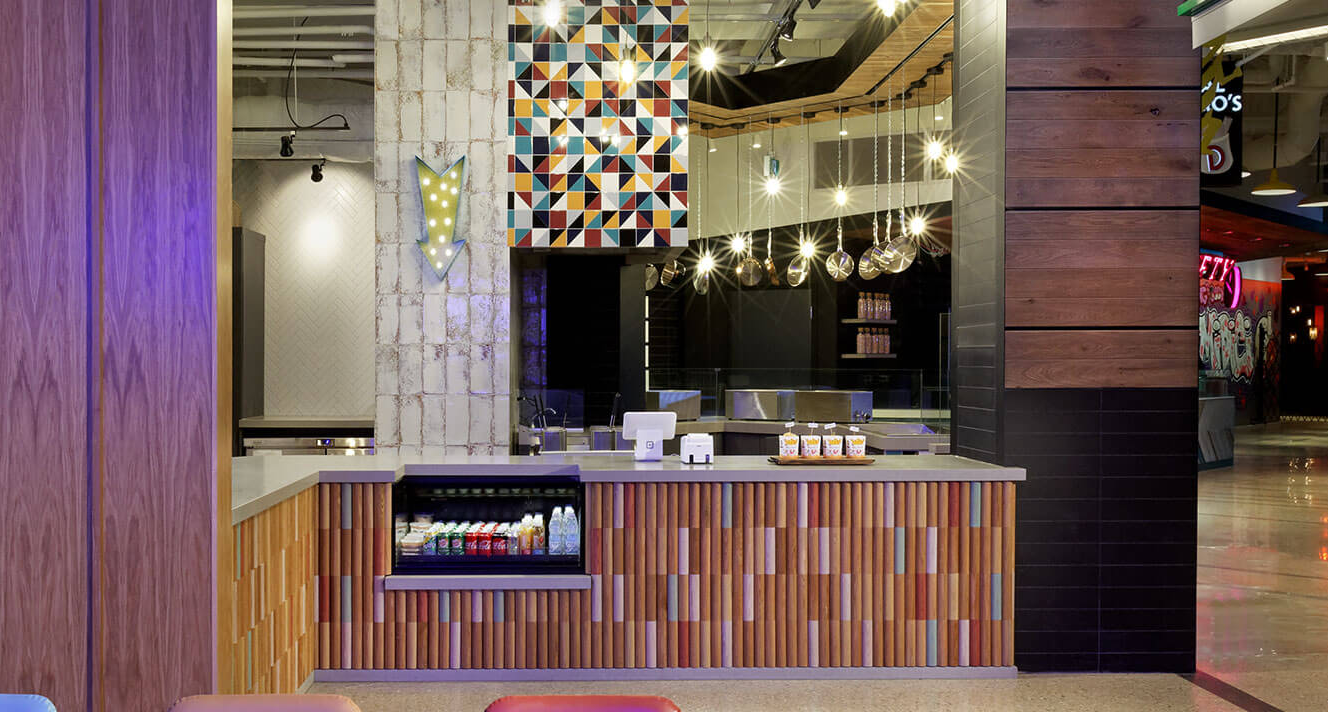 A restaurant with a wooden counter and a purple wall.