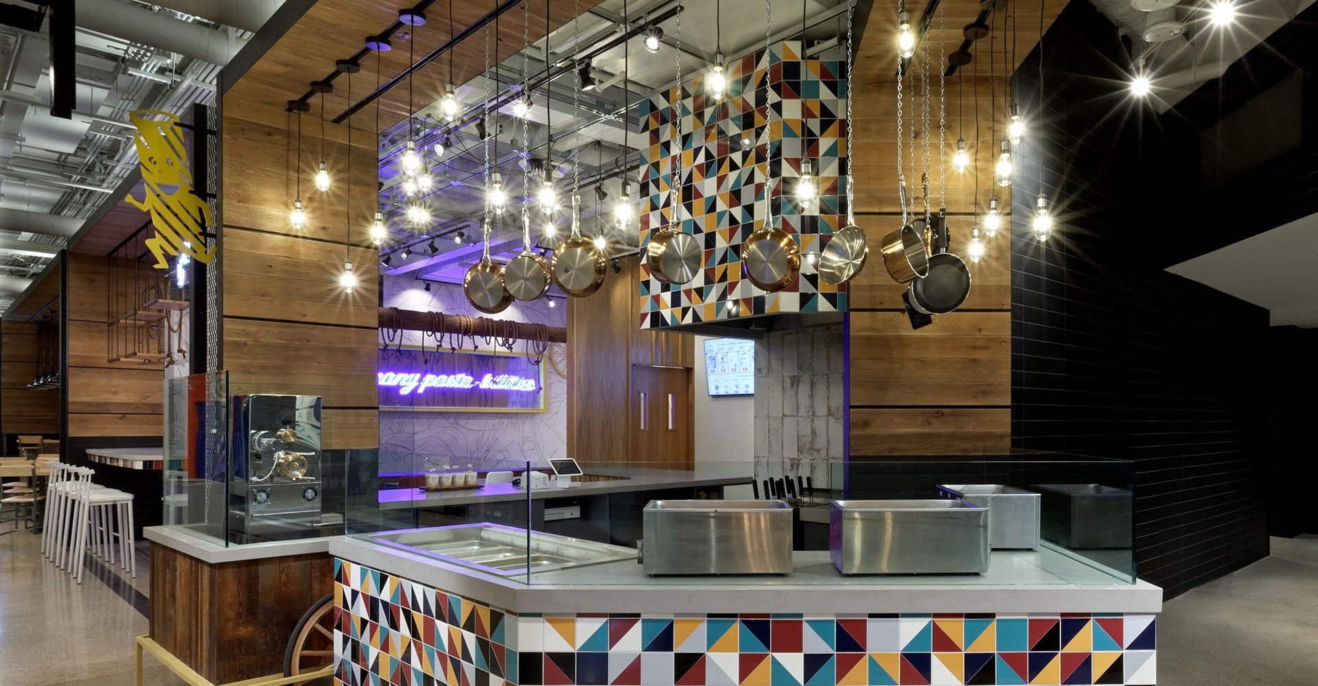 A restaurant with a colorful counter top and lots of lights hanging from the ceiling.