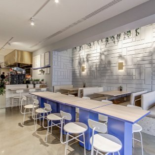 A restaurant with blue tables and white chairs