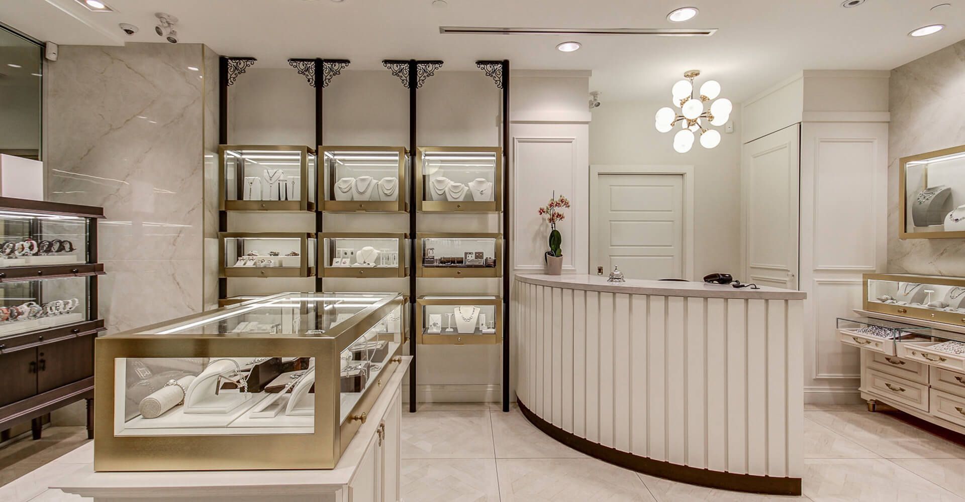 A jewelry store with a curved counter and shelves filled with jewelry.