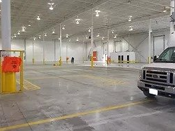 A truck is parked in an empty warehouse.