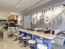 A restaurant with tables and chairs and a brick wall.