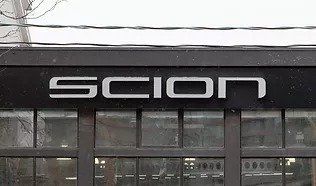 The scion logo is on the side of a building.