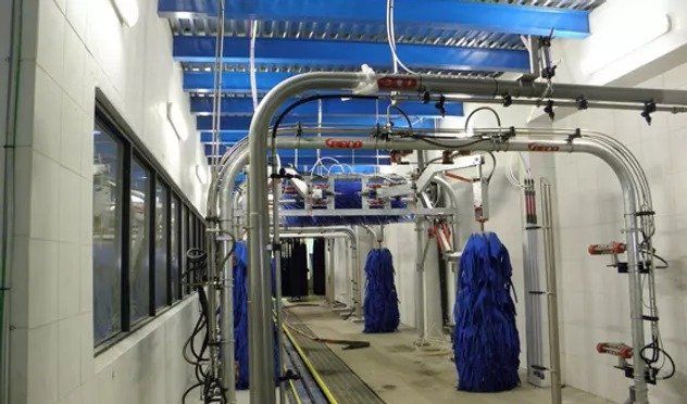 A car wash with blue brushes hanging from the ceiling