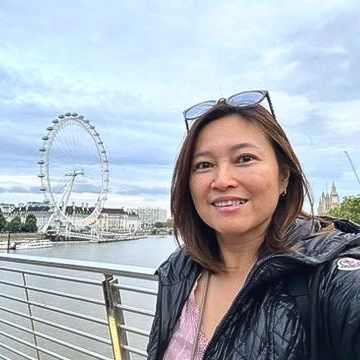 A woman is taking a selfie with a ferris wheel in the background.