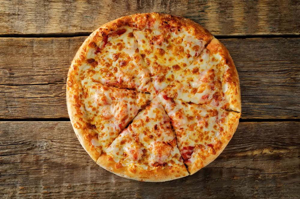 Cheese pizza on a rustic wooden table, viewed from above Cheese pizza on a rustic wooden table, viewed from above