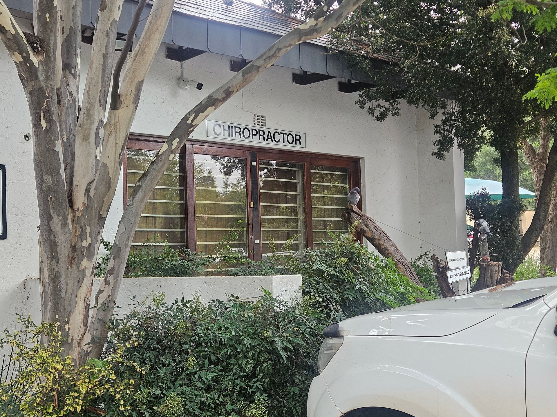 A white building with a glass window and a sign that reads 