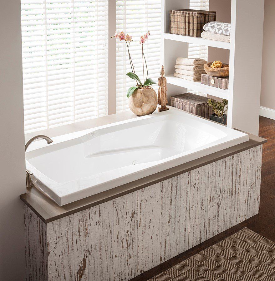 Gray tiled wall with a square recessed vent or decorative panel featuring a geometric lattice pattern