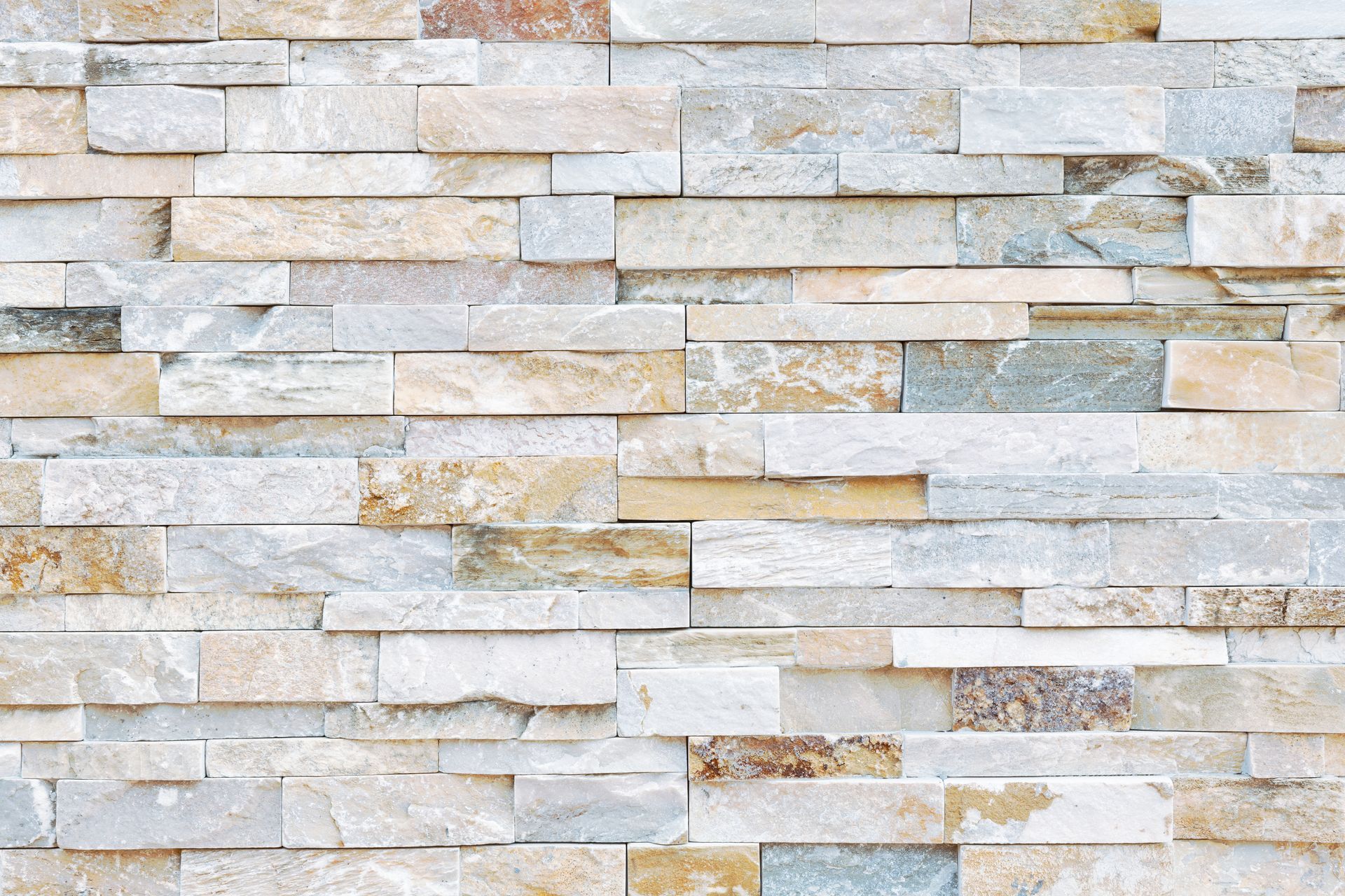 Light beige stacked stone wall with horizontal textured blocks